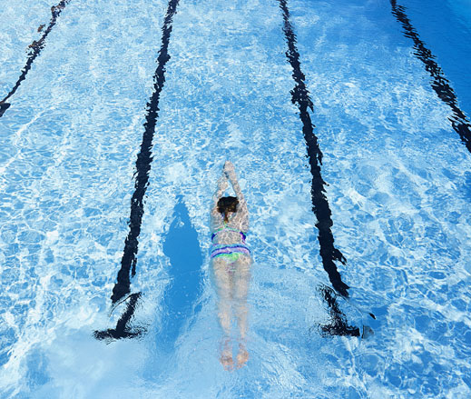 Image of a lady swimming in an outdoor pool