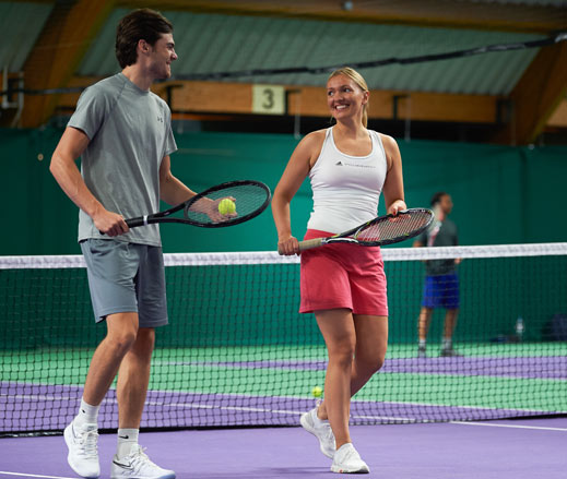 Image of man and woman enjoying tennis game